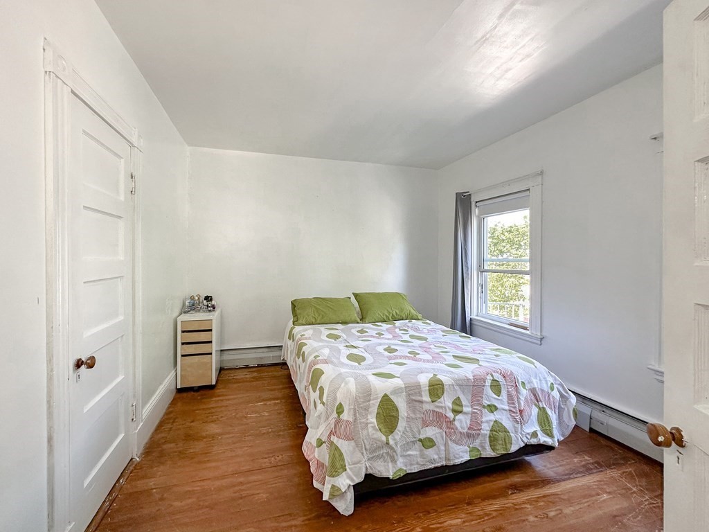 82 Jefferson Avenue Everett, MA 02149 - Photo 17 of 37 a bedroom with a bed and wooden floor