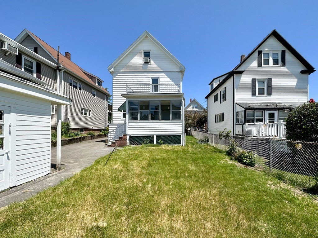 82 Jefferson Avenue Everett, MA 02149 - Photo 2 of 37 a front view of a house with a yard table and chairs