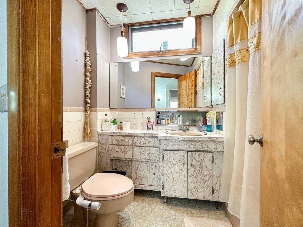 82 Jefferson Avenue Everett, MA 02149 - Photo 22 of 37 a bathroom with a granite countertop toilet sink and a mirror