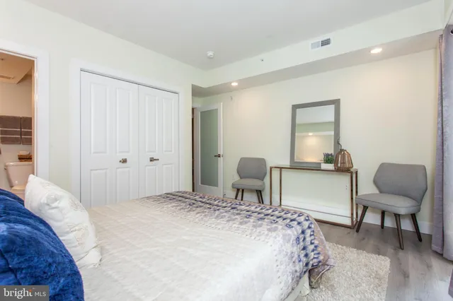 a bedroom with a bed chair and a mirror