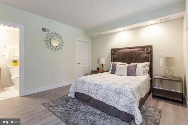 a bedroom with a bed and painting on the wall