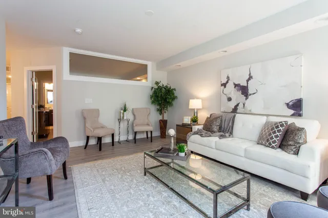 a living room with furniture a rug and a table