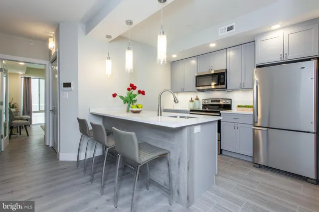 a kitchen with kitchen island white cabinets and stainless steel appliances