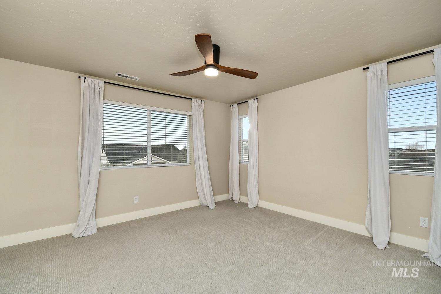 5771 West Daphne Drive Meridian, ID 83646 - Photo 18 of 32 Unfurnished bedroom featuring light carpet, a ceiling fan, and a textured ceiling