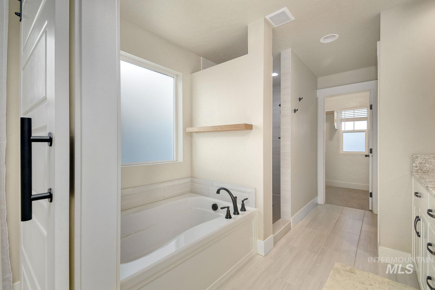 5771 West Daphne Drive Meridian, ID 83646 - Photo 22 of 32 Full bath featuring a bath, vanity, and walk in shower