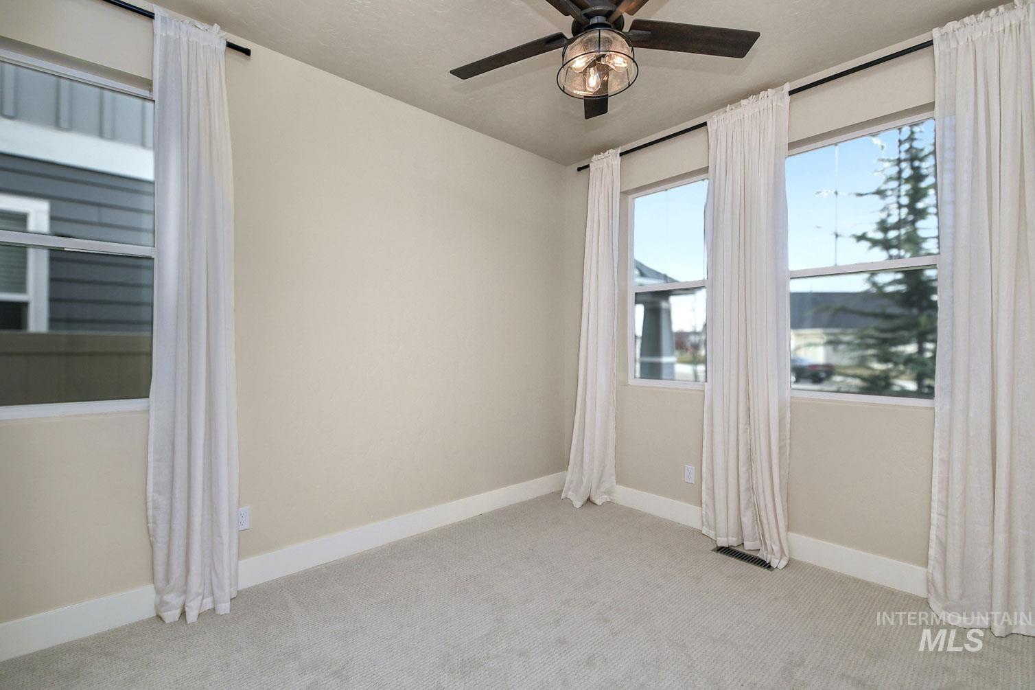 5771 West Daphne Drive Meridian, ID 83646 - Photo 6 of 32 Unfurnished room with light colored carpet and ceiling fan
