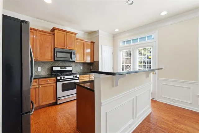 a kitchen with stainless steel appliances granite countertop a stove a sink and a refrigerator