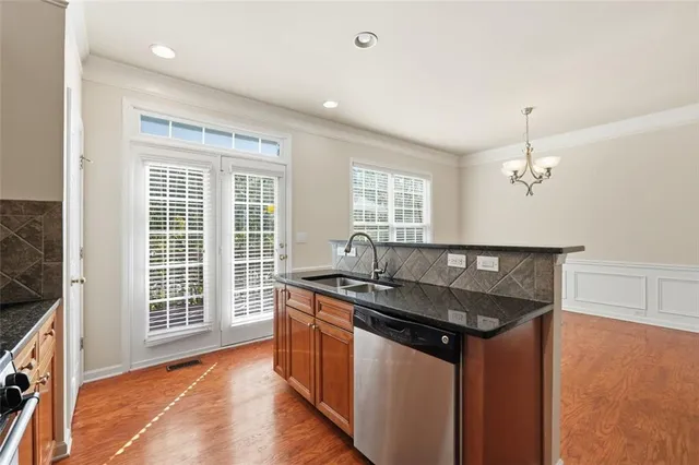 a kitchen that has a sink a window and stainless steel appliances
