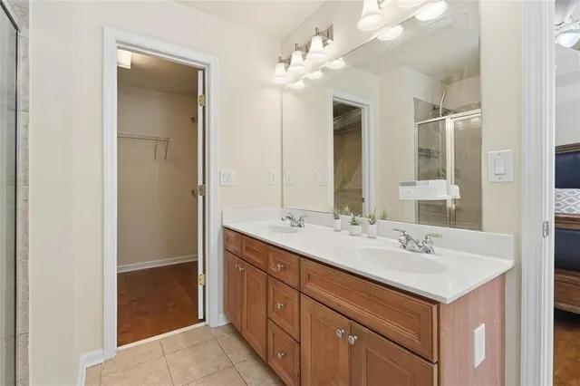 a bathroom with a sink double vanity granite tub shower and a mirror