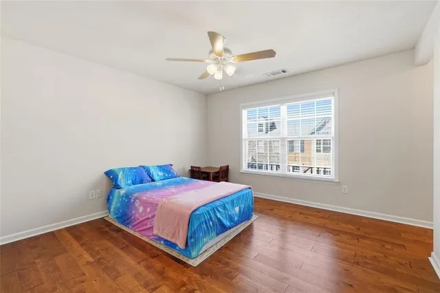 a bedroom with a bed and a chandelier fan