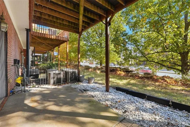 a view of a room with wooden floor next to a yard