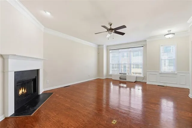 a view of empty room with wooden floor and fireplace