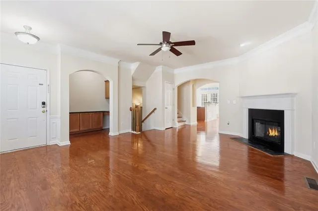 a view of a livingroom with a fireplace a ceiling fan and windows