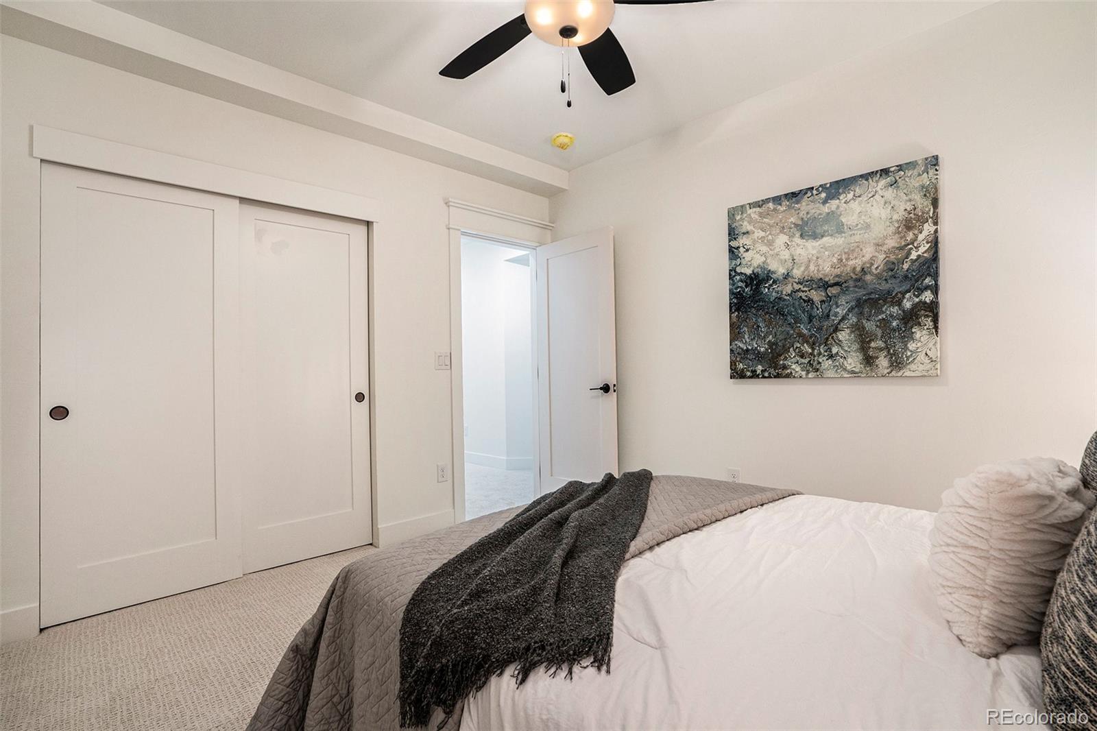 3271 Perry Street Denver, CO 80212 - Photo 32 of 34 a bedroom with a large bed and a chandelier