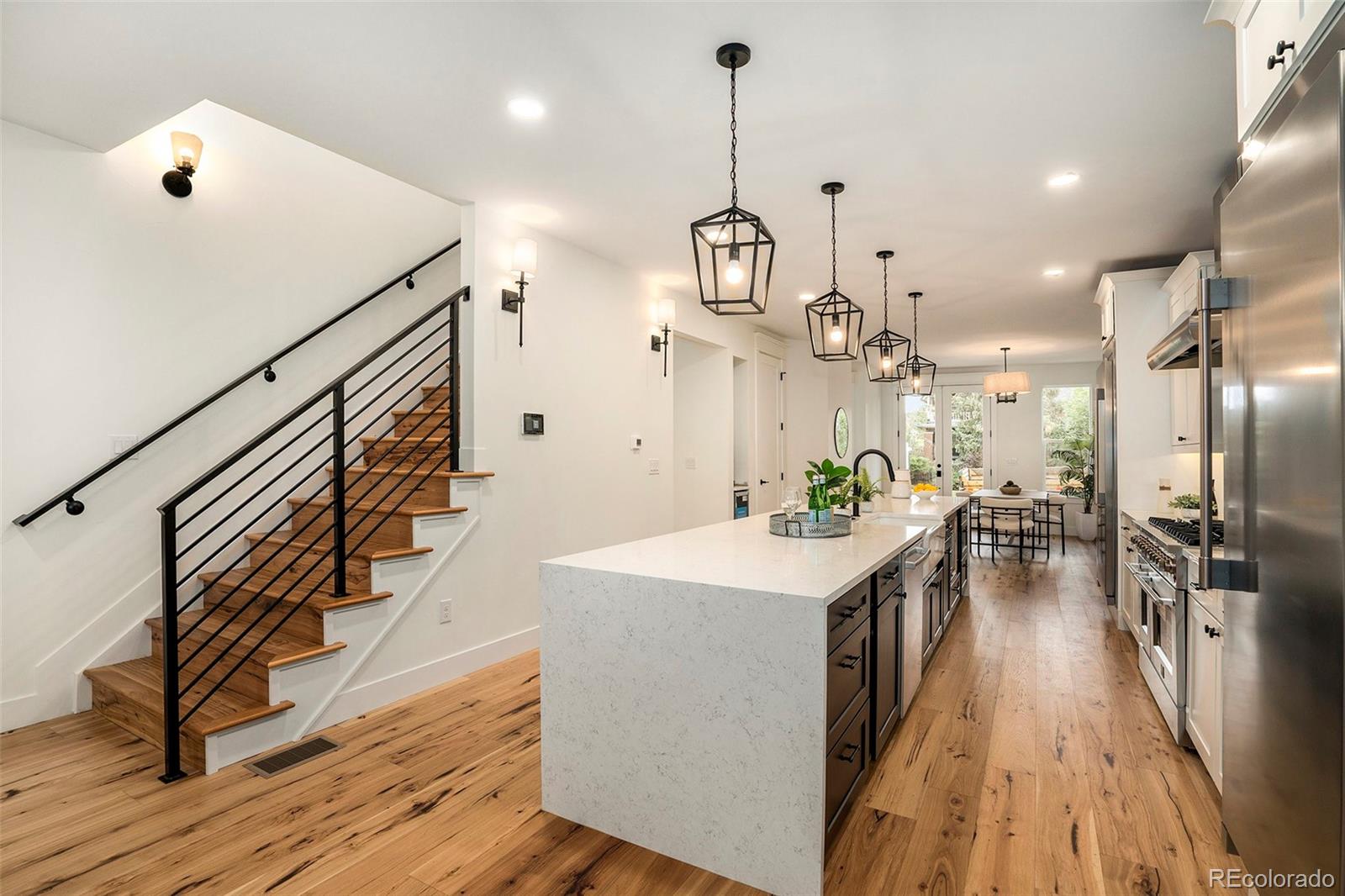 3271 Perry Street Denver, CO 80212 - Photo 5 of 34 a kitchen with stainless steel appliances kitchen island a island in the center and wooden floor