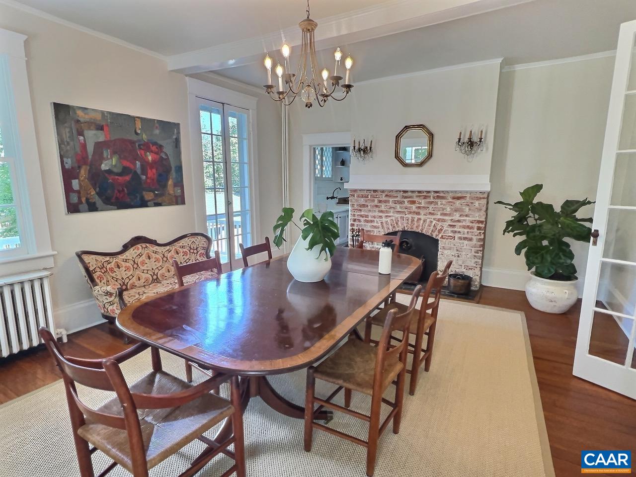 1326 Rugby Road Charlottesville, VA 22903 - Photo 11 of 65 a view of a dining room with furniture a chandelier and wooden floor