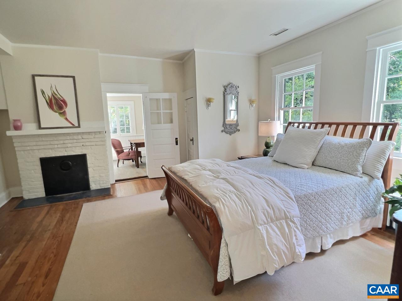 1326 Rugby Road Charlottesville, VA 22903 - Photo 25 of 65 a spacious bedroom with a balcony a bed and a fireplace