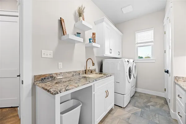 a utility room with sink dryer and washer