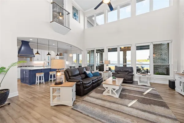 a living room with furniture large window and wooden floor