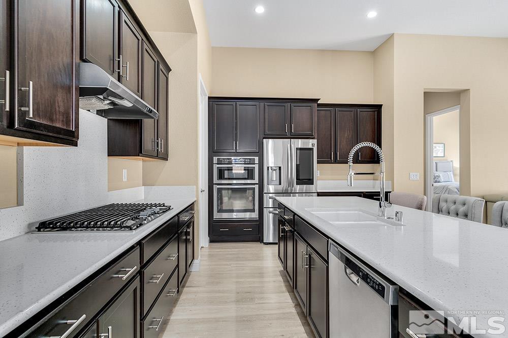 9545 Hawkshead Road Reno, NV 89521 - Photo 8 of 29 a kitchen with stainless steel appliances a sink stove and refrigerator
