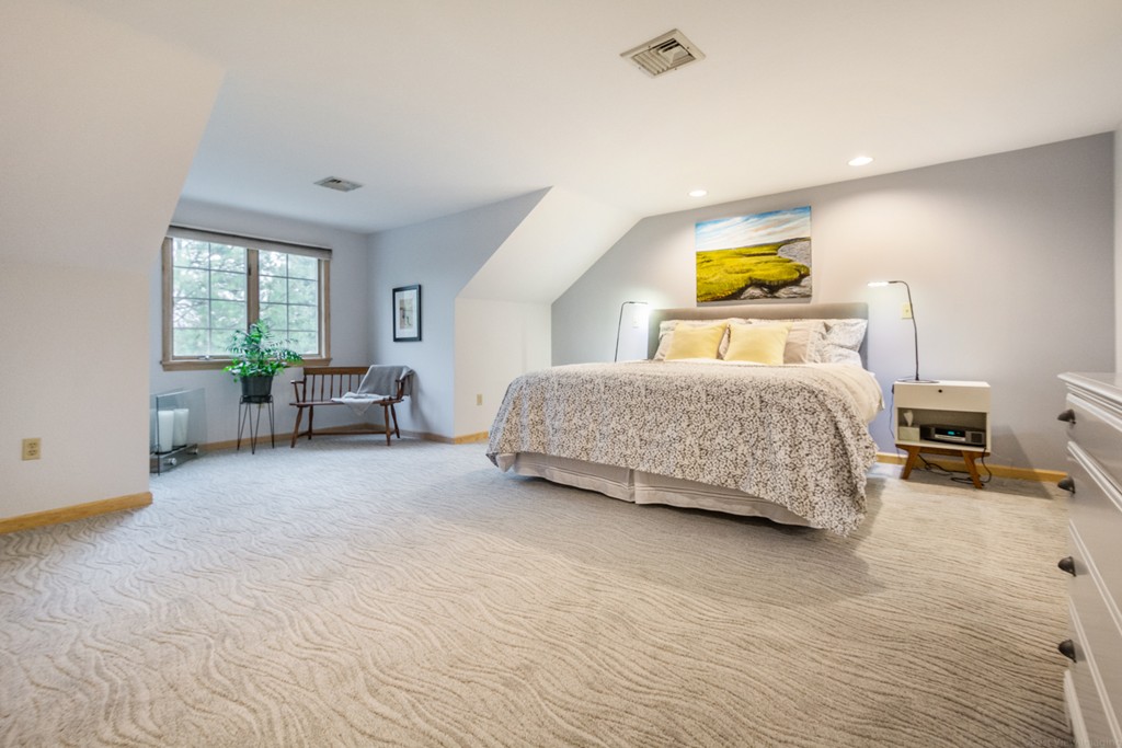 9 Powder Hill Way, Unit 9 Westborough, MA 01581 - Photo 17 of 30 a bedroom with a bed and mirror