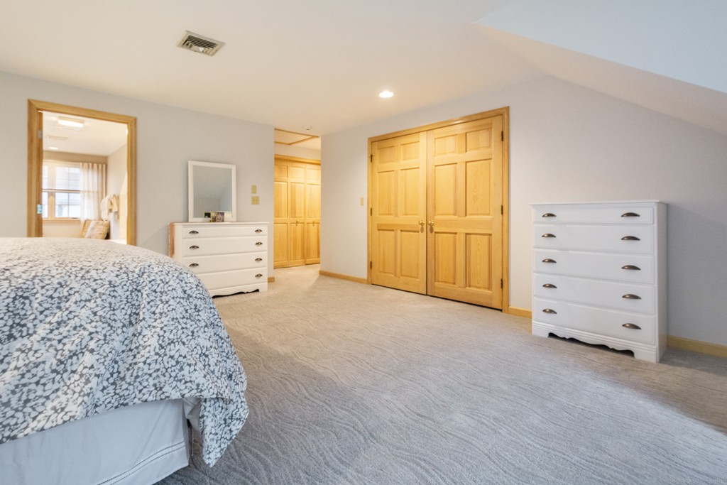 9 Powder Hill Way, Unit 9 Westborough, MA 01581 - Photo 18 of 30 a spacious bedroom with a large bed and wooden floor