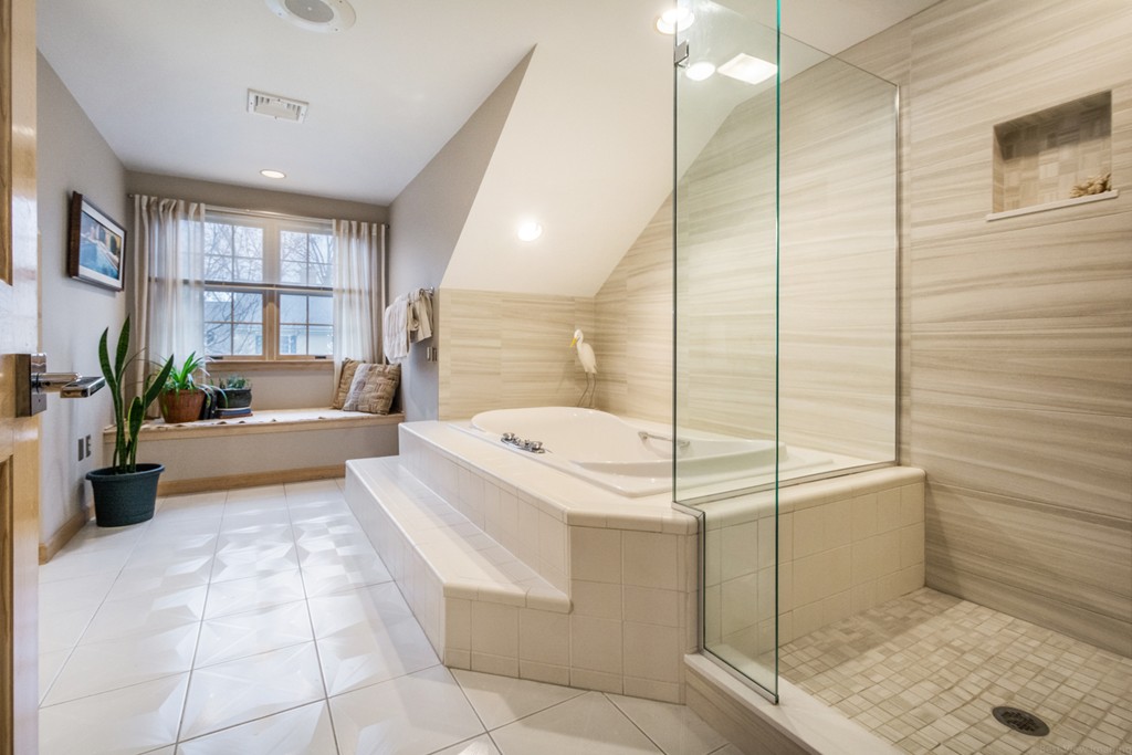9 Powder Hill Way, Unit 9 Westborough, MA 01581 - Photo 19 of 30 a bathroom with a tub a mirror and a shower