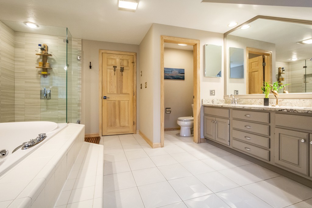 9 Powder Hill Way, Unit 9 Westborough, MA 01581 - Photo 21 of 30 a spacious bathroom with a mirror a double vanity sink a shower and a bathtub