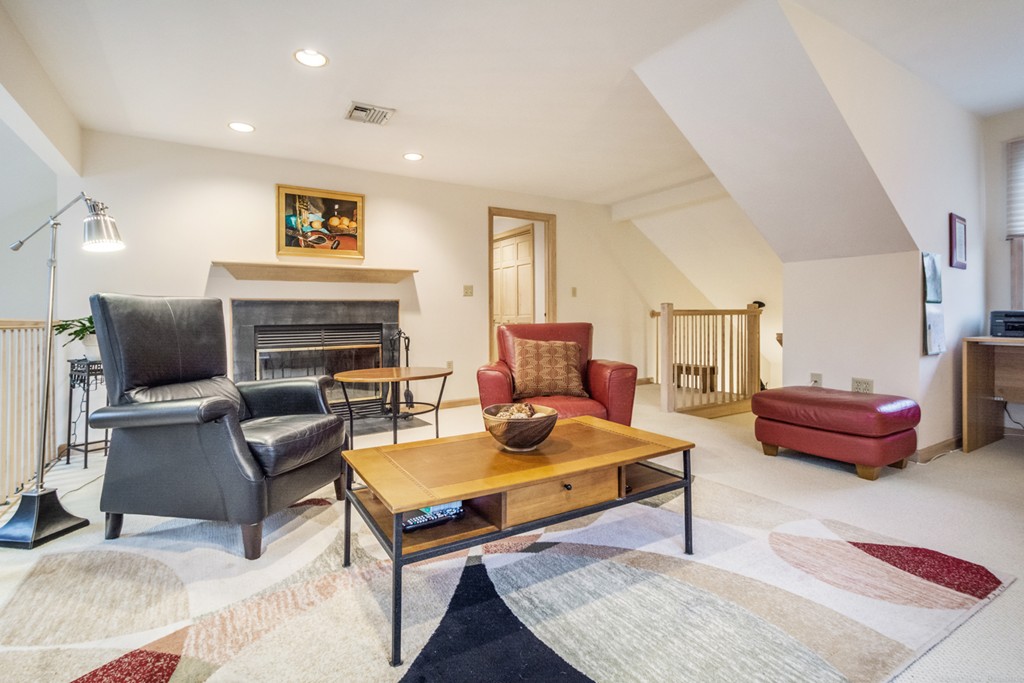 9 Powder Hill Way, Unit 9 Westborough, MA 01581 - Photo 25 of 30 a living room with furniture a flat screen tv and a fireplace