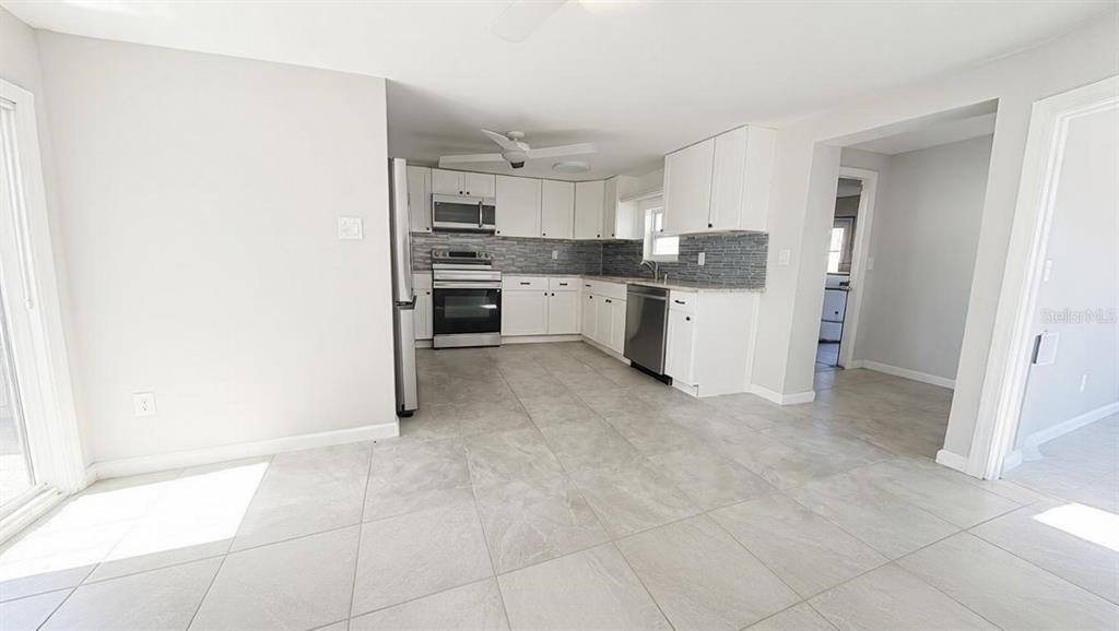 4033 Newcastle Drive New Port Richey, FL 34652 - Photo 10 of 12 a kitchen with granite countertop a refrigerator and cabinets