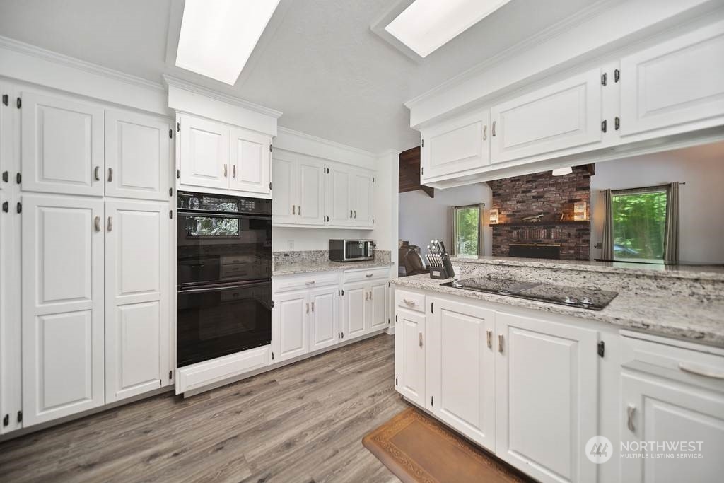 1171 Big Pine Way Forks, WA 98331 - Photo 11 of 40 a kitchen with granite countertop white cabinets and refrigerator