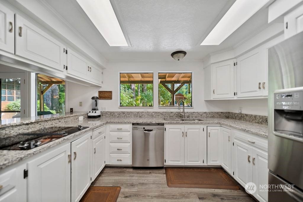 1171 Big Pine Way Forks, WA 98331 - Photo 10 of 40 a kitchen with granite countertop white cabinets white appliances a sink and a window