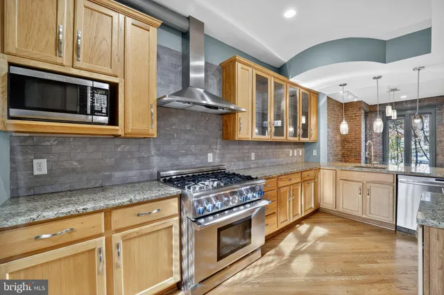 a kitchen with stainless steel appliances granite countertop a stove and a microwave