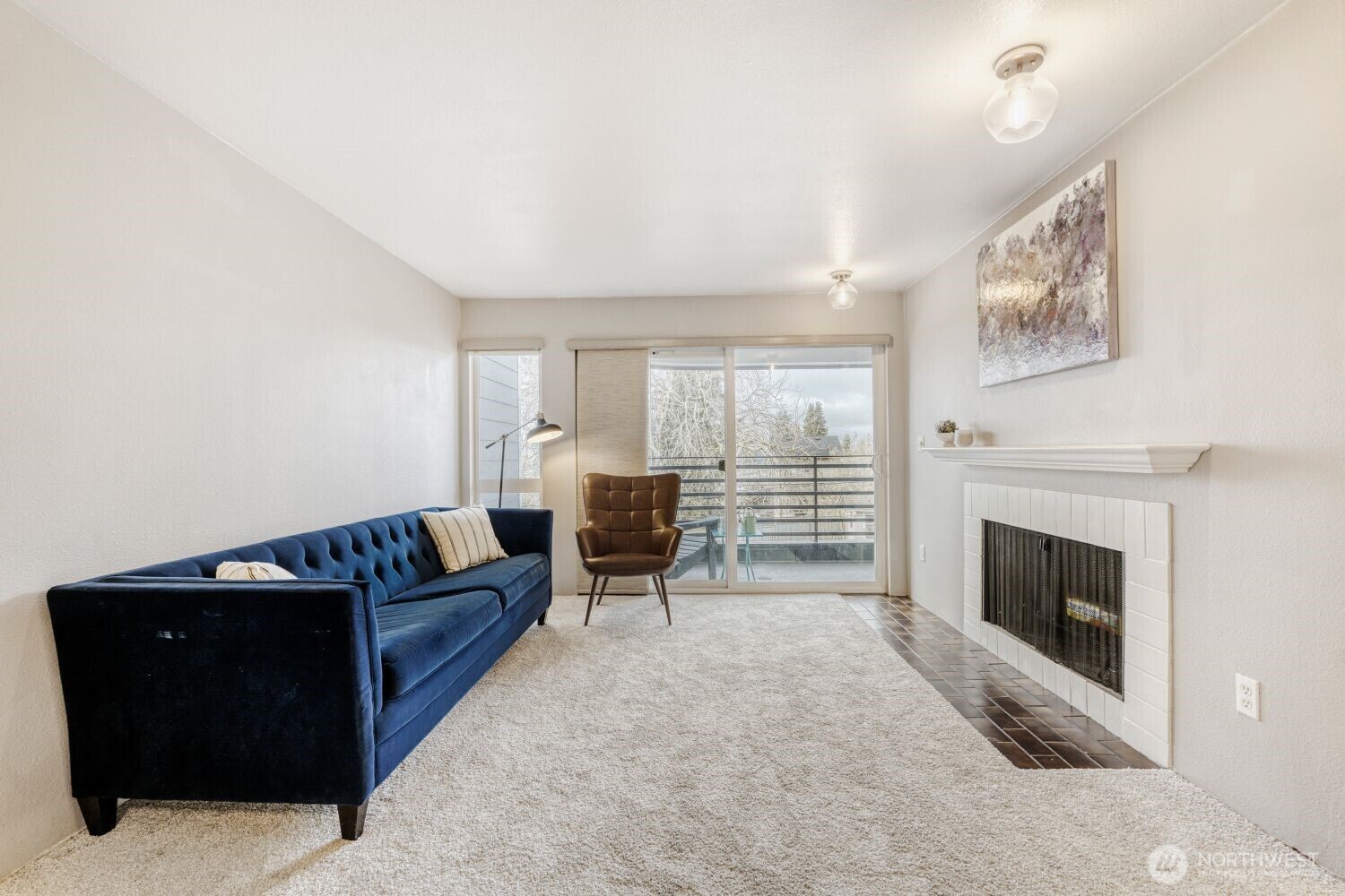 3501 Southwest Holden Street, Unit 303 Seattle, WA 98126 - Photo 11 of 30 a living room with furniture and a fireplace