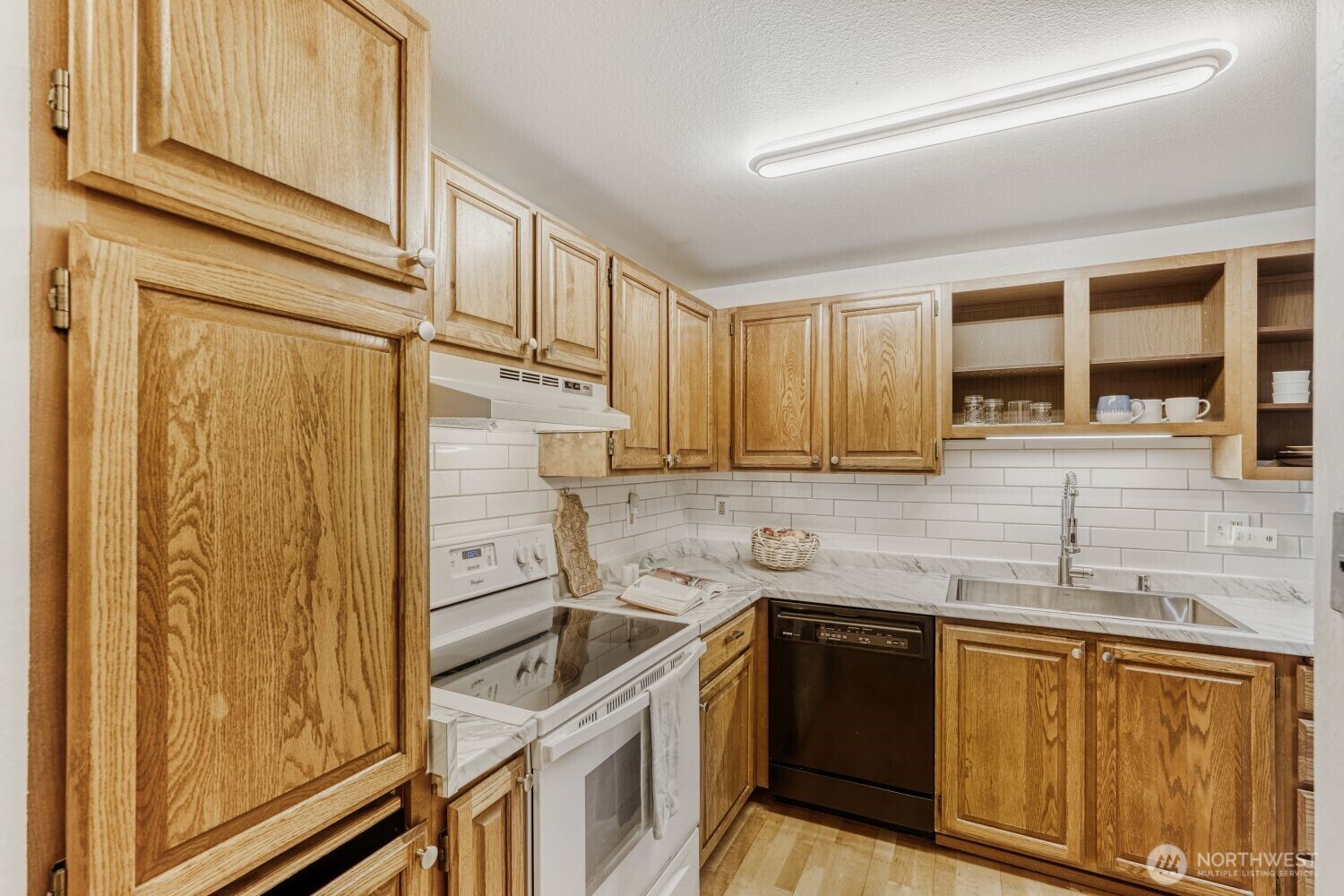 3501 Southwest Holden Street, Unit 303 Seattle, WA 98126 - Photo 5 of 30 a kitchen with stainless steel appliances granite countertop a sink stove and refrigerator