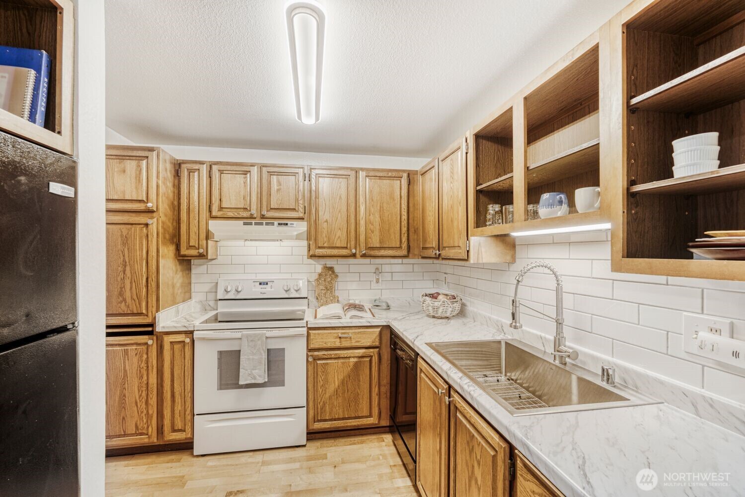 3501 Southwest Holden Street, Unit 303 Seattle, WA 98126 - Photo 7 of 30 a kitchen with granite countertop a sink stainless steel appliances and cabinets