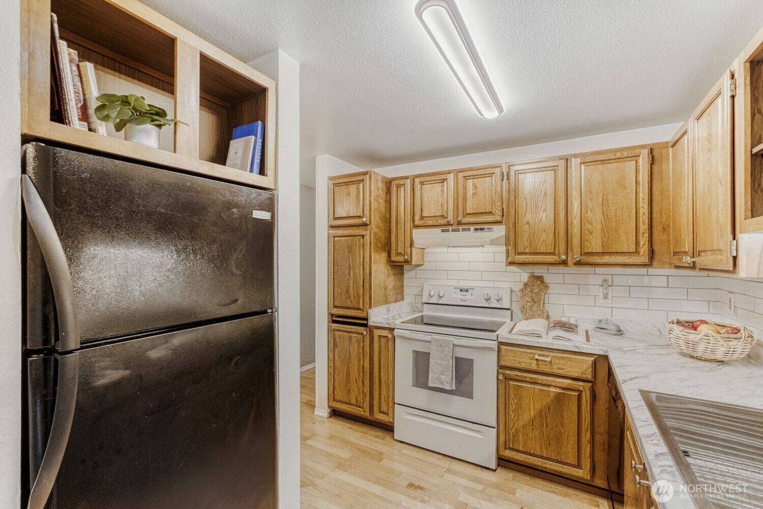 3501 Southwest Holden Street, Unit 303 Seattle, WA 98126 - Photo 8 of 30 a kitchen with stainless steel appliances granite countertop a refrigerator and a stove top oven
