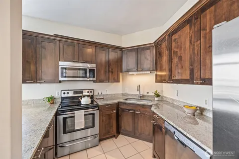 a kitchen with stainless steel appliances granite countertop a sink stove microwave and cabinets