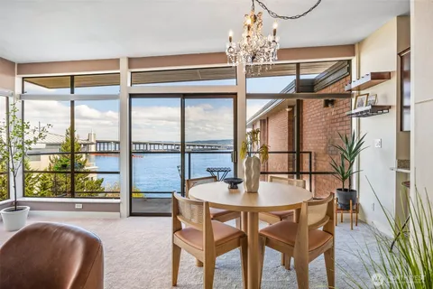 a dining room with furniture a chandelier and wooden floor