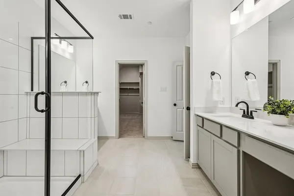 a bathroom with a double vanity sink a mirror and shower