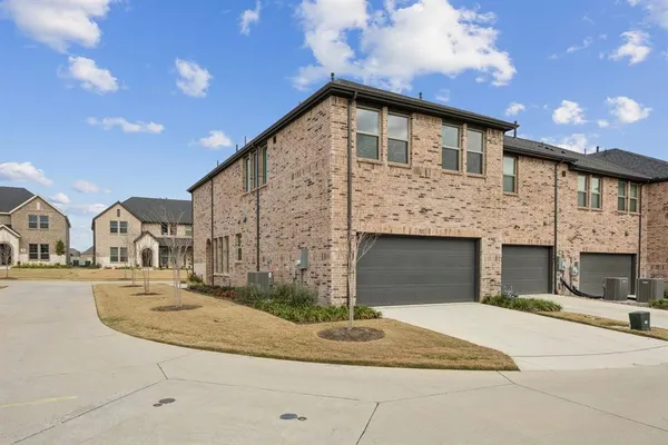 a front view of a house with yard and parking