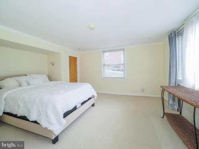 a large bed sitting in a bedroom next to a window