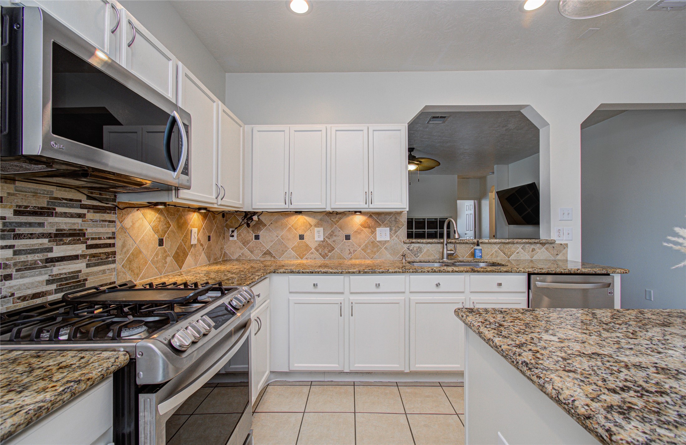24135 Pinecreek Point Spring, TX 77373 - Photo 11 of 30 a kitchen with stainless steel appliances granite countertop a stove and a microwave