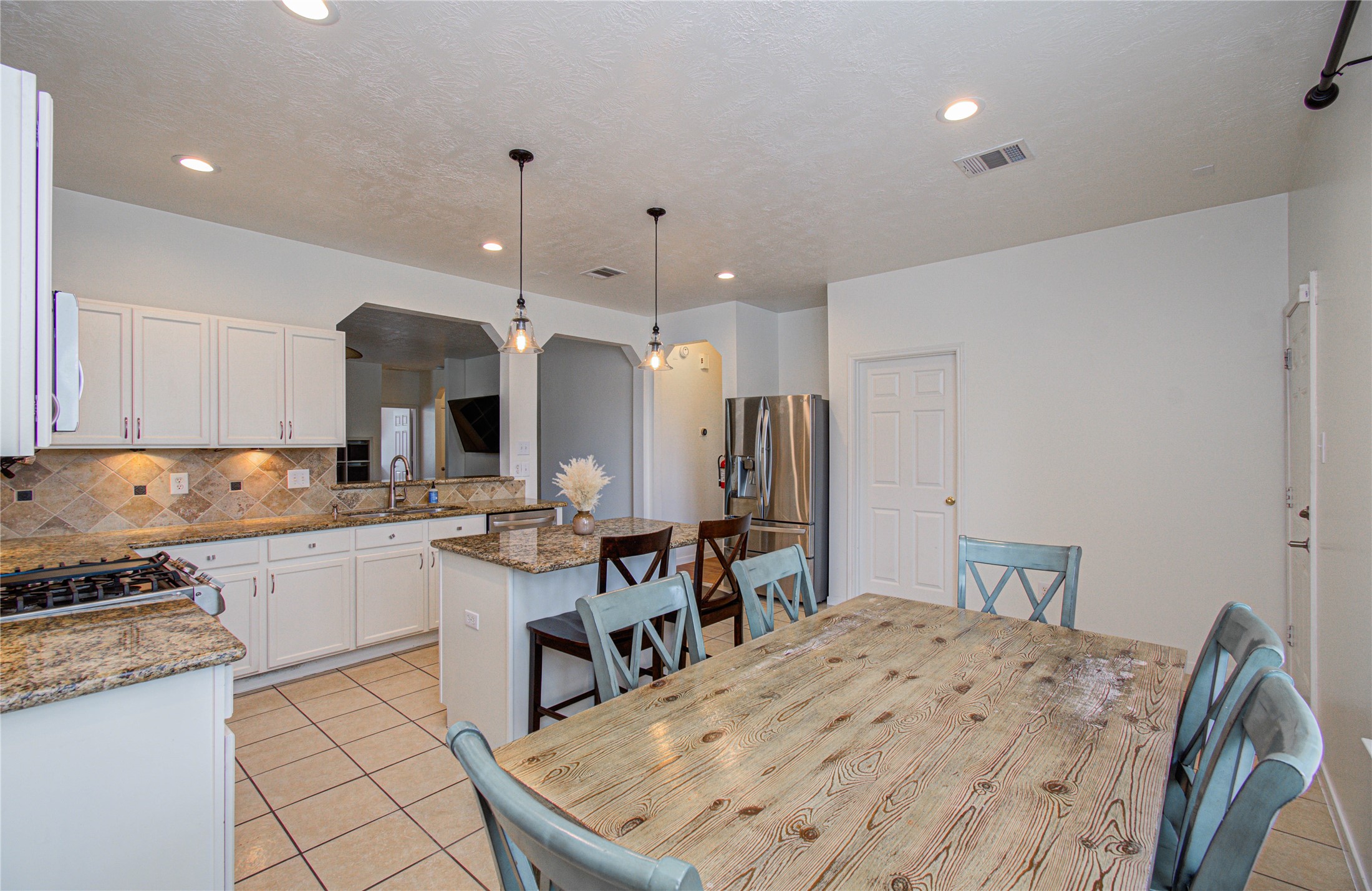 24135 Pinecreek Point Spring, TX 77373 - Photo 13 of 30 a large kitchen with kitchen island a sink stove and white cabinets