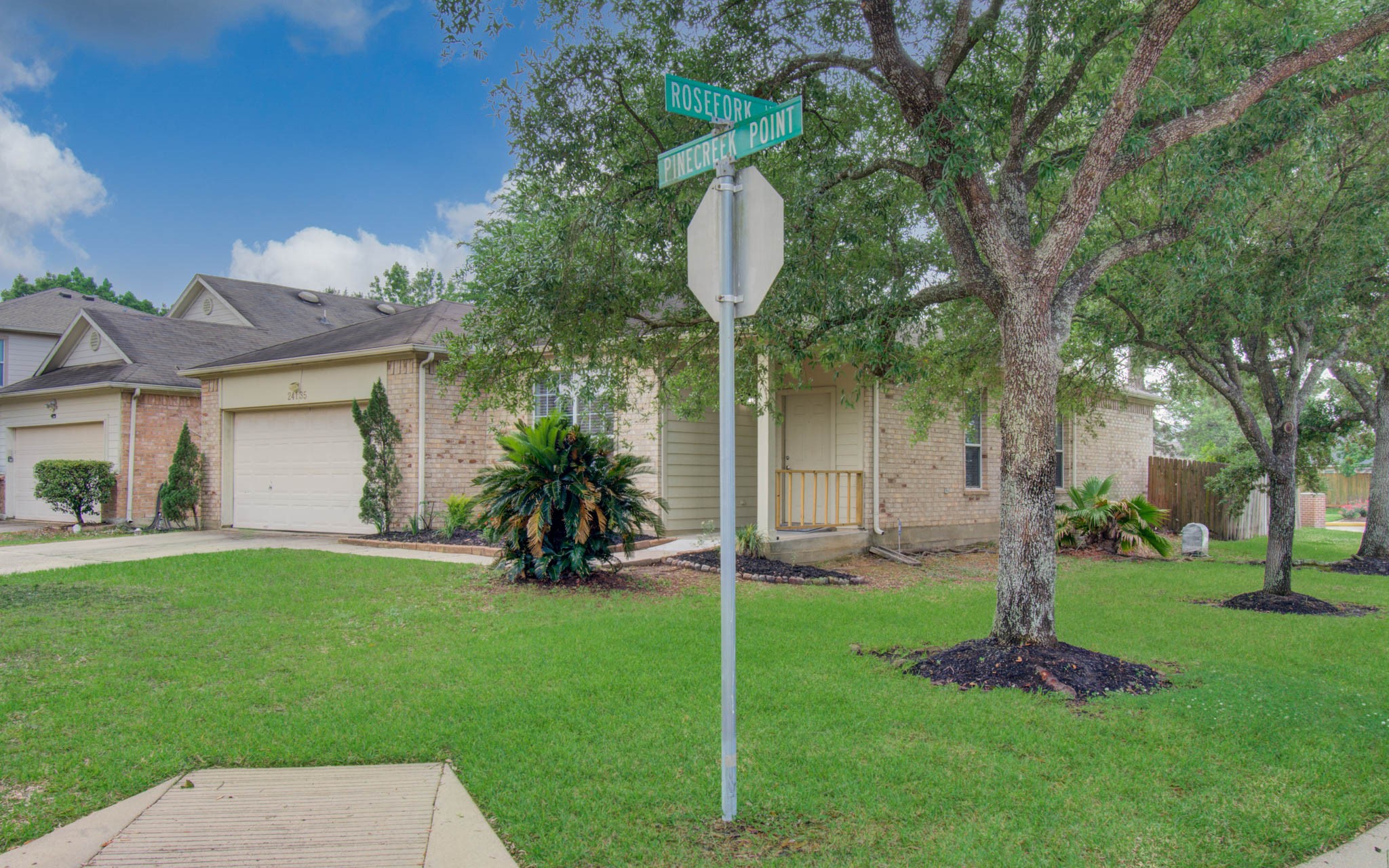 24135 Pinecreek Point Spring, TX 77373 - Photo 2 of 30 a backyard of a house with table and chairs plants and large tree