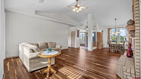 a view of a livingroom and dining room with furniture wooden floor and a chandelier