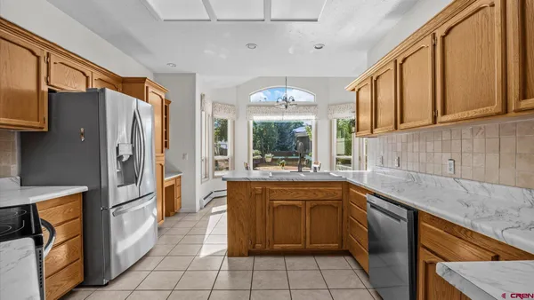 a large kitchen with stainless steel appliances granite countertop a sink and cabinets