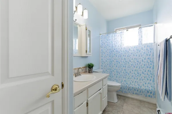 a bathroom with a sink a toilet and shower curtain