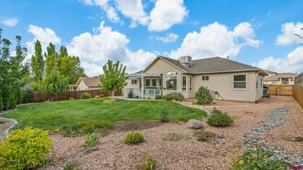 a view of a house with a big yard plants and large trees