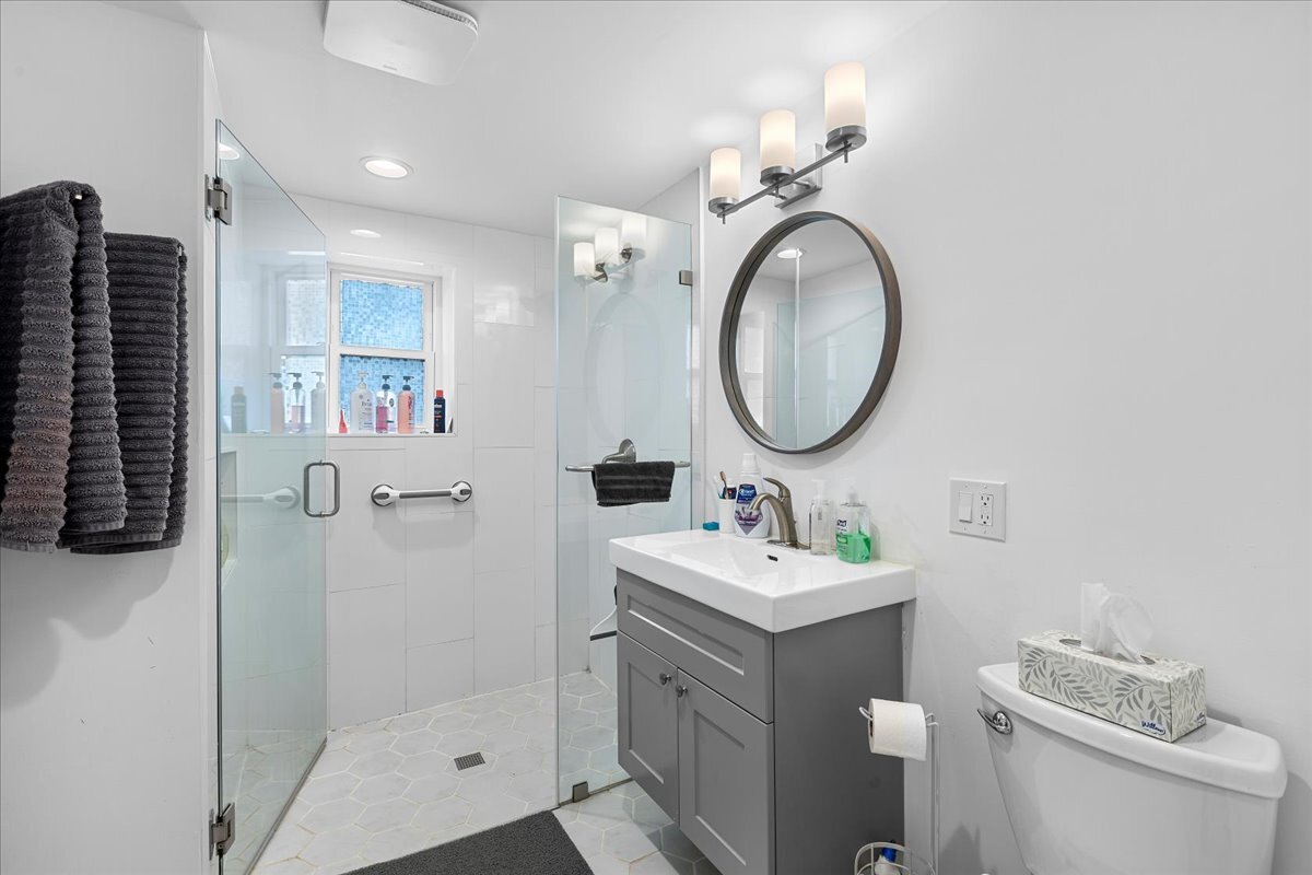 3144 North Spaulding Avenue, Unit 1 Chicago, IL 60618 - Photo 11 of 13 a bathroom with a toilet a sink and a mirror
